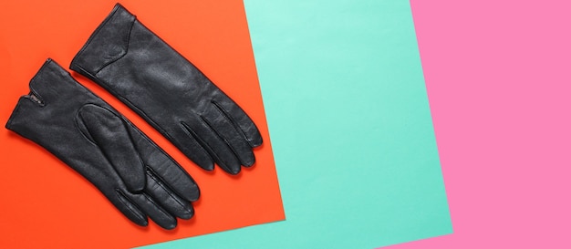 Photo gants en cuir sur fond de couleur créative. vue de dessus. minimalisme de la mode