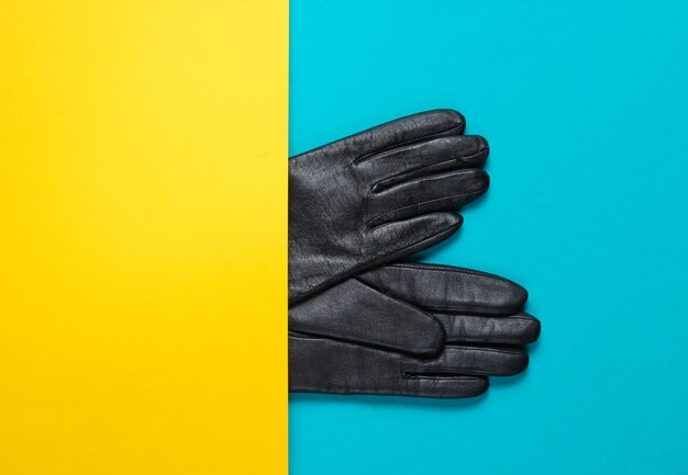 Photo gants demi-cuir sur table jaune-bleu. concept de mode créative de minimalisme. vue de dessus