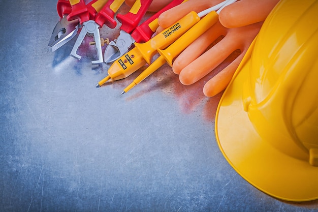 Gants d'électriciens casque de construction testeur électrique pince pinces décapants d'isolation sur fond métallique