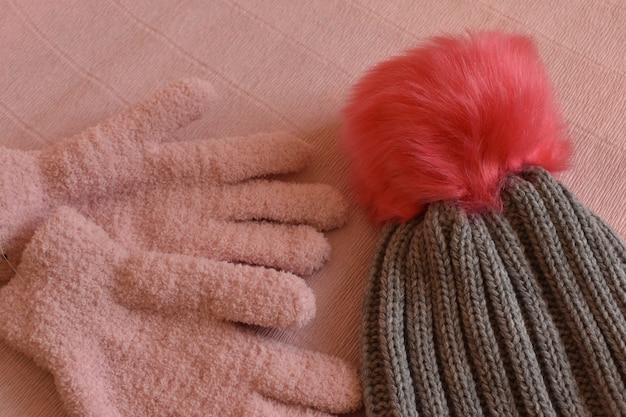 Photo gants d'hiver et une casquette sur fond rose