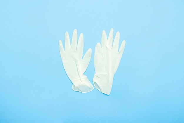 Gants en latex médical sur fond bleu. Concept médecine, infirmière, hôpital, sécurité, épidémie. Mise à plat, vue de dessus