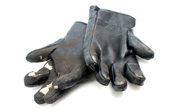 gants noirs utilisés durement en lambeaux sur l'image blanche