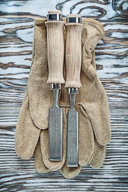 Gants de protection ciseaux plats sur planche de bois.