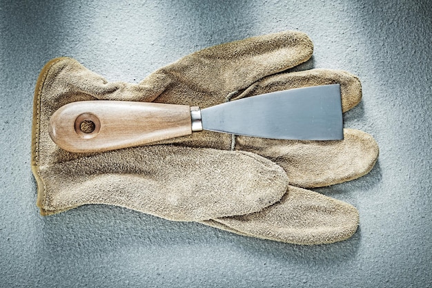 Gants de protection en cuir de couteau à palette sur le concept de construction de fond en béton.