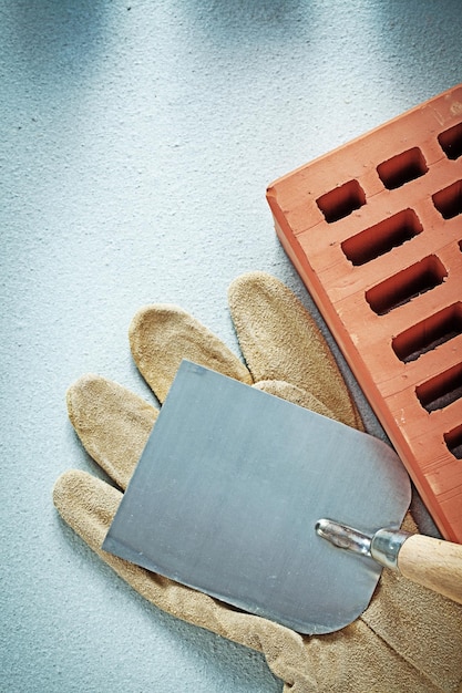 Gants de sécurité en brique de construction truelle de plâtrage sur le concept de maçonnerie de surface en béton.