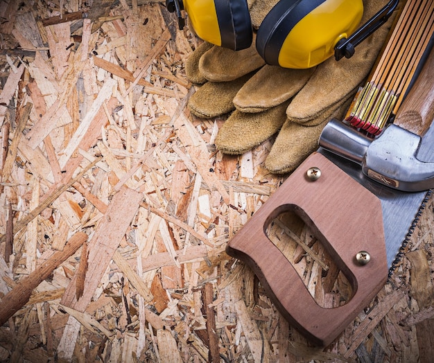 Gants de sécurité mètre en bois scie à main griffe marteau cache-oreilles sur OSB