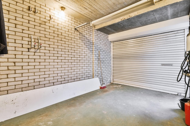 Garage spacieux avec porte blanche fermée et murs en briques avec cintres dessus
