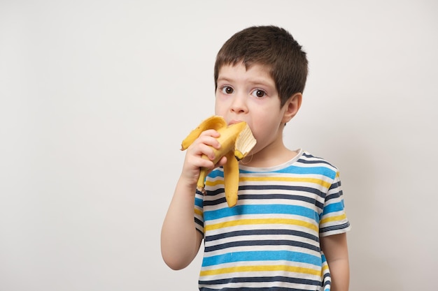 Un garçon de 4 ans mange une banane