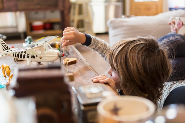 Photo garçon de 4 ans en pyjama jouant avec des jouets à la maison