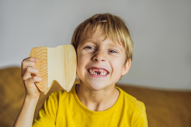 Un garçon de 6 ans tient une boîte pour les dents de lait Changement de dents