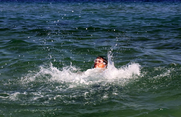 Garçon actif nageant dans l'eau de mer.