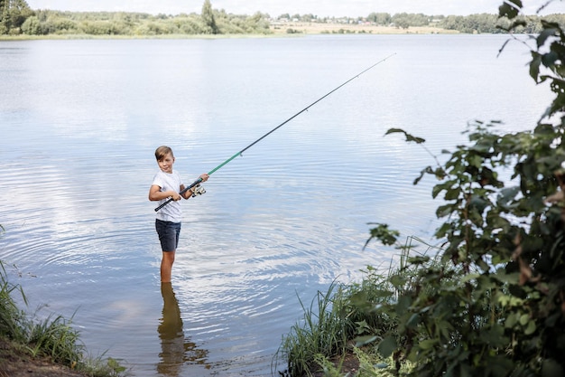 Garçon adolescent pêchant avec des cannes dans une rivière calme Vie lente à la campagne