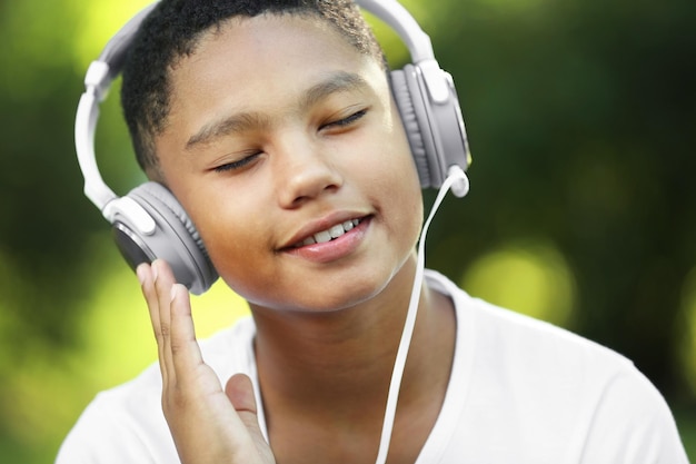 Garçon afro-américain écoutant de la musique dans le parc