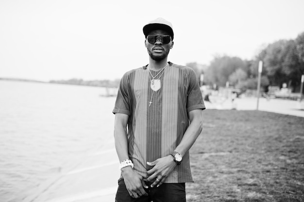 Un garçon afro-américain élégant porte un t-shirt de football et des lunettes de soleil Portrait d'homme de sport noir