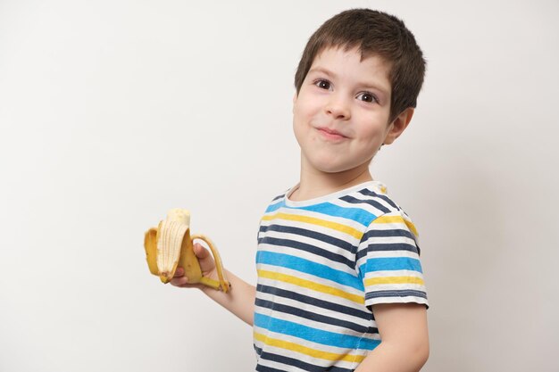 Un garçon d'âge préscolaire d'un an avec une banane