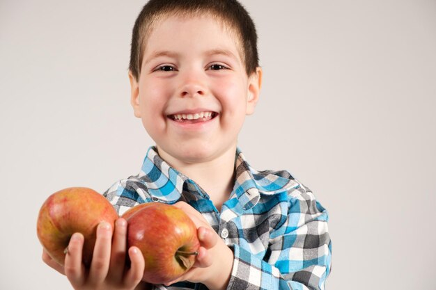 Un garçon d'âge préscolaire d'un an avec des pommes rouges