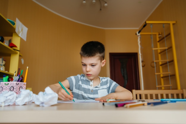 garçon d'âge scolaire fait ses devoirs à la maison. Formation à l'école