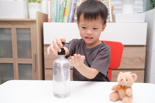 Garçon à l'aide de gel désinfectant sur les mains