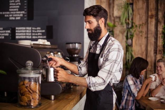 Garçon à l'aide d'une machine à café