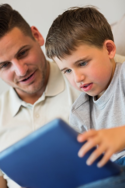 Garçon à l&#39;aide de tablette numérique avec père