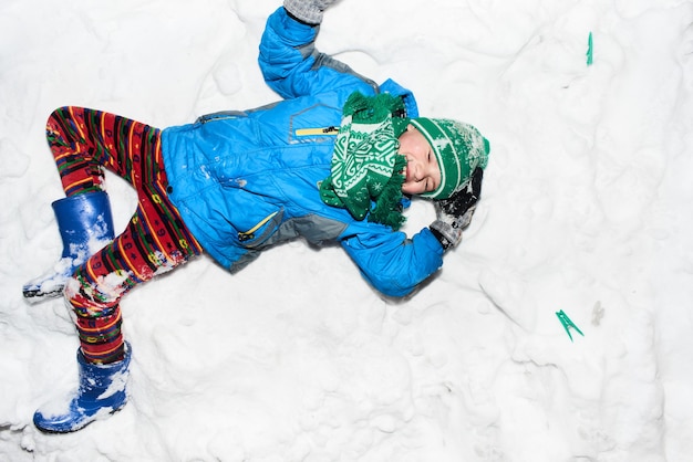 Garçon allongé sur la neige