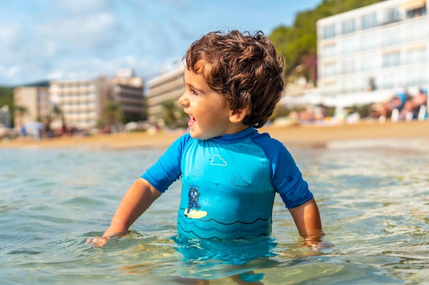 Garçon d'un an s'amusant dans la mer Plage d'Ibiza en vacances à la plage de San Vicente Baléares