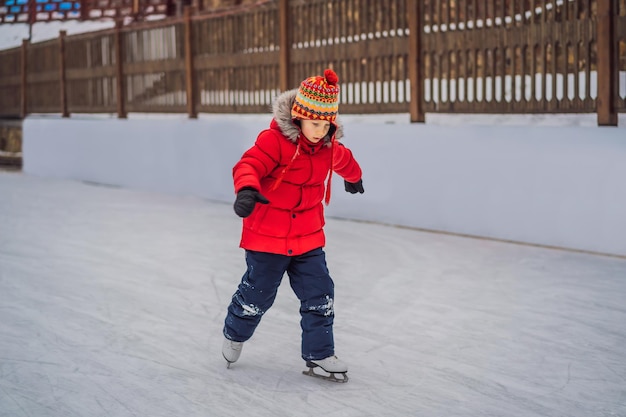 Un garçon apprend juste à patiner sur glace