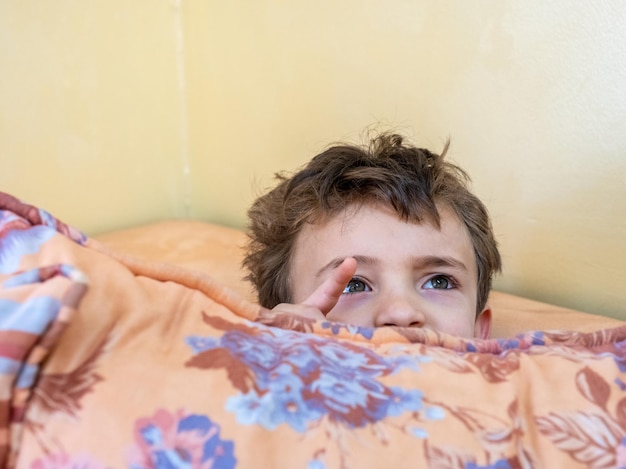 Garçon arabe jouant à cache-cache et se cachant derrière un coussin