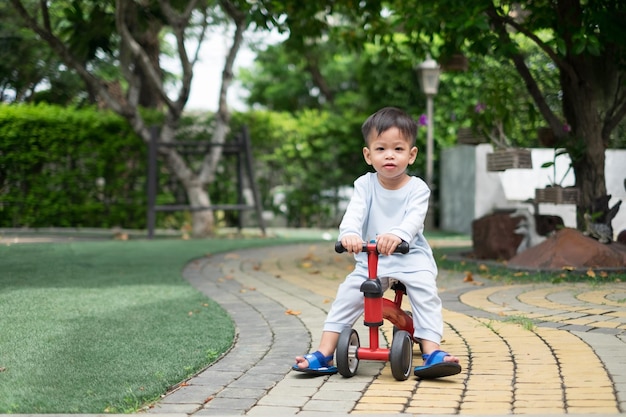 Garçon asiatique de 1 an jouant à vélo dans sa maison