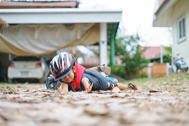 Un garçon asiatique âgé d&#39;environ 2 ans fait du vélo d&#39;équilibre pour bébé et tombe