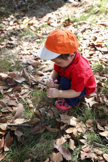 Photo garçon asiatique est assis dans le jardin.