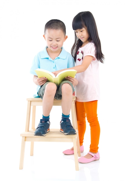 Garçon asiatique mignon et fille lisant un livre