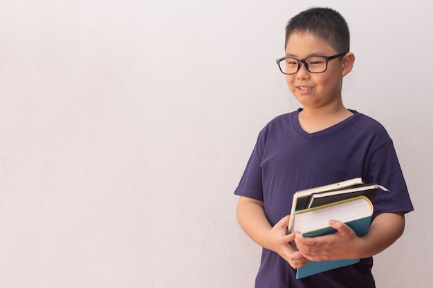 Garçon d'Asie tenant des livres prêts pour l'école