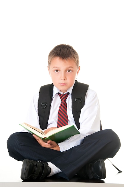 Un garçon assidu lit un livre et se prépare aux examens et aux tests.