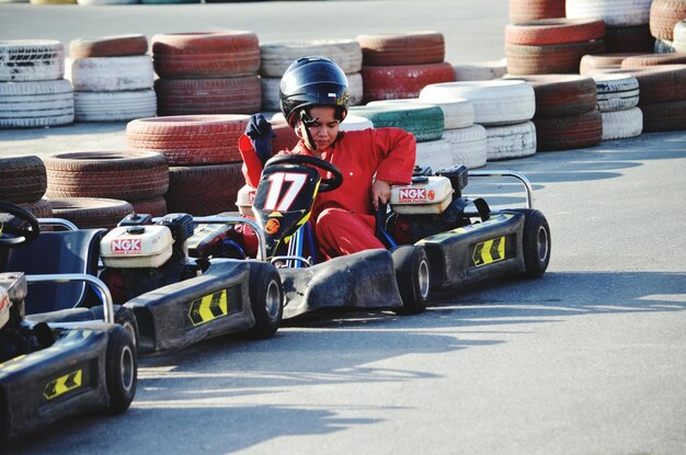 Photo un garçon assis dans une voiture de course