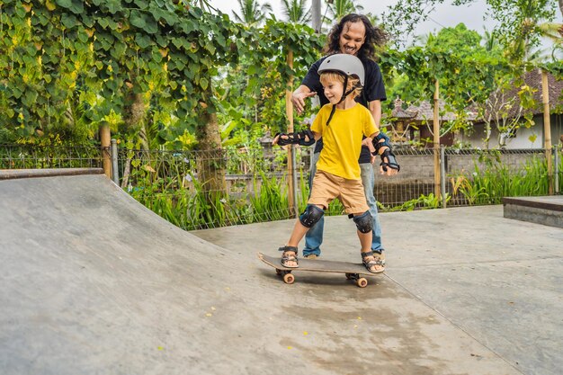 Un garçon athlétique apprend à faire du skateboard avec un entraîneur dans un skate park Sports d'éducation pour enfants