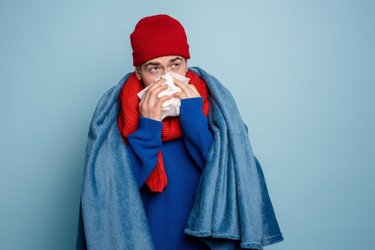Photo le garçon a attrapé un rhume et a des frissons froids studio sur fond cyan