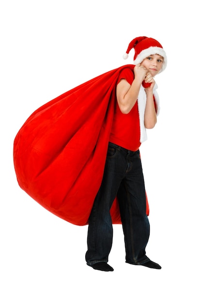 Garçon au chapeau de père Noël avec sac cadeau de Noël rouge sur blanc