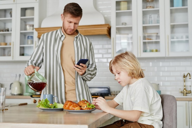 Garçon au petit déjeuner avec le père