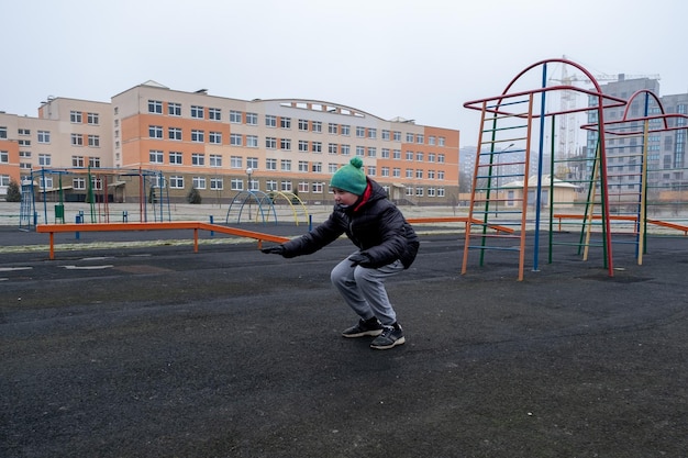 Photo le garçon au stade court et fait du sport.