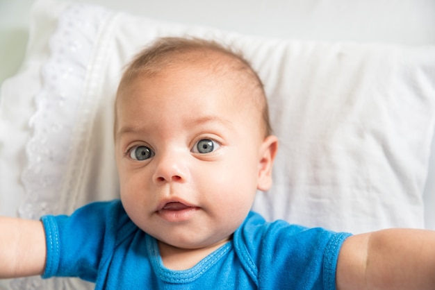 Garçon aux yeux bleus couché dans un berceau