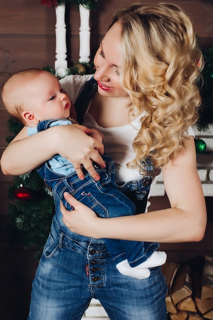 Garçon Avec Belle Maman Blonde Embrassant Dans Une Maison Décorée Pour Noël