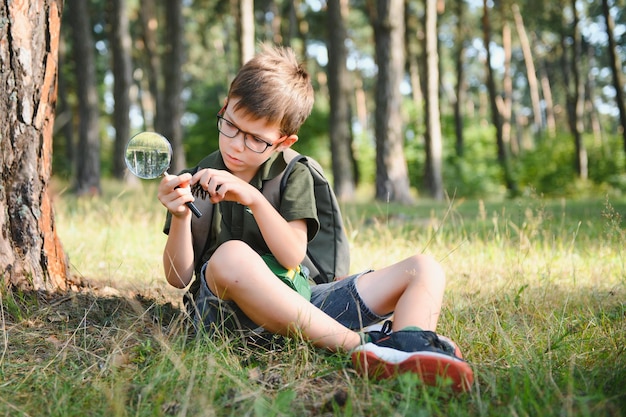 Un garçon biologiste ou entomologiste étudie la nature Scout dans la forêt Un adolescent étudie les insectes Biologie Géologie Expédition dans la forêt