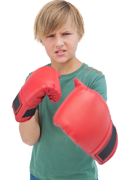 Garçon blond furieux avec des gants de boxe