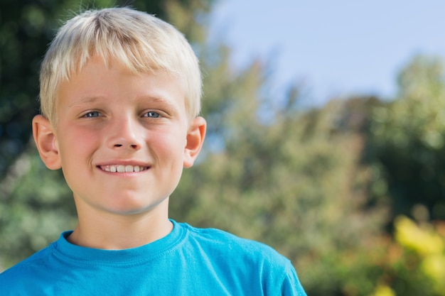 Garçon blond mignon, souriant à la caméra