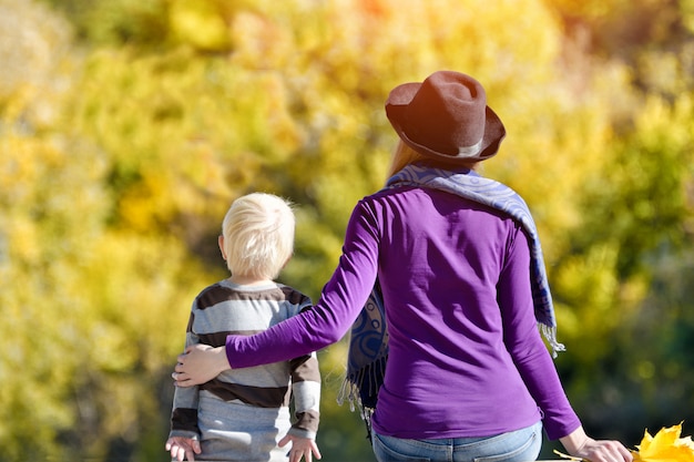 Garçon blond avec sa mère assise sur la rive du fleuve