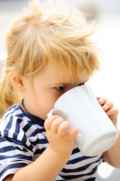 Le garçon boit une tasse de lait