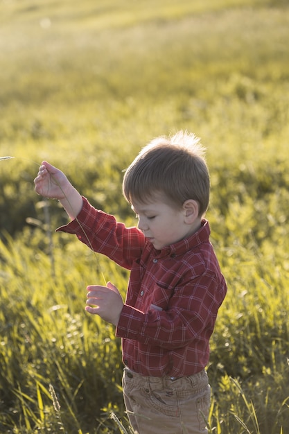 Un garçon avec un bouquet de fleurs dans les mains pour maman.