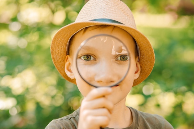 Garçon caucasien explorant l'environnement naturel avec une loupe loupe