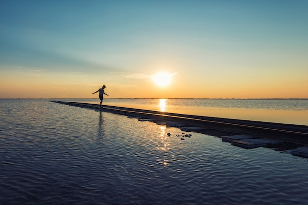 Garçon sur chemin de fer au coucher du soleil beauté